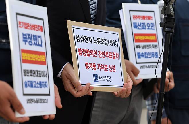 26일 오전 경기 수원시 수원지법 청사 앞에서 삼성전자 디바이스경험(DX) 부문 직원들이 주축이 된 삼성전자 노동조합 동행(동행노조) 집행부가 삼성전자 노사 임금협상 잠정합의안 찬반 투표 중지 등 가처분 신청서를 제출하기 전 취재진의 질문에 답하고 있다. 연합뉴스