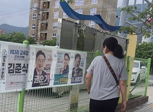 사전투표를 앞두고 한 시민이 경남교육감 선거 후보 벽보를 살펴보고 있다. /문정민 기자