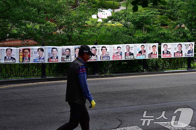 6·3전국동시지방선거 사전투표일(29일)을 사흘 앞둔 26일 경북 포항시 남구 대잠동 영일대호수공원에 걸려있는 선거 벽보 앞으로 시민이 지나가고 있다. 2026.5.26 ⓒ 뉴스1 최창호 기자
