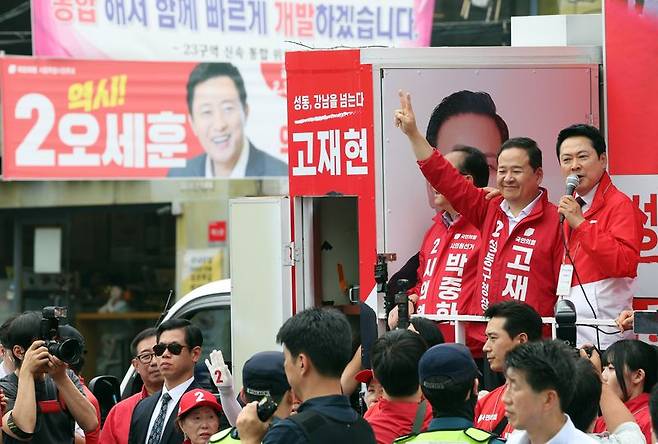 장동혁 국민의힘 대표(오른쪽)가 26일 오후 서울 성동구 금남시장에서 유권자들에게 지지를 호소하고 있다. 연설하는 장 대표 옆으로 오세훈 서울시장 후보의 현수막이 걸려 있다. 뉴스1