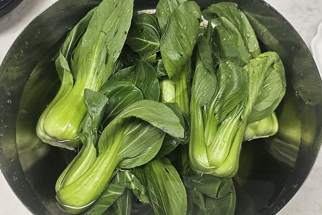 청경채는 먼저 밑동 부분을 손질하는 것이 중요하다. 뿌리와 단단한 밑동을 칼로 잘라낸 뒤 잎을 한 장씩 분리하면 숨어 있던 흙과 이물질을 제거할 수 있다. 찬물에 2~3분 정도 담가 두었다가 손으로 가볍게 흔들어주면 이물질이 자연스럽게 떨어진다. 박윤희 기자