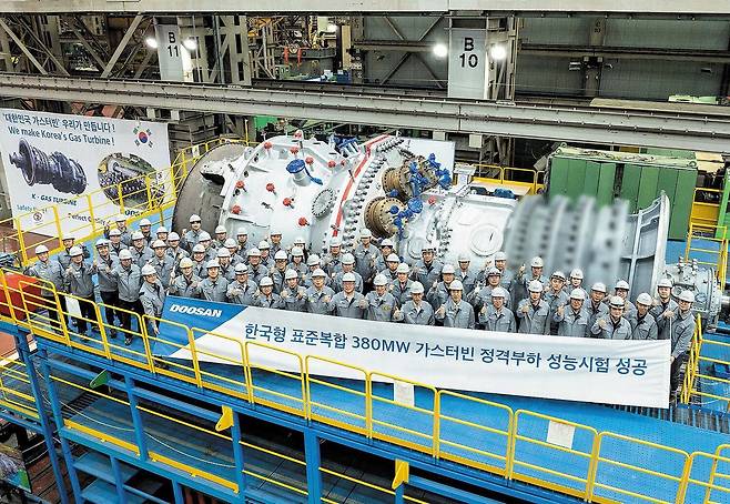 두산에너빌리티 관계자들이 380메가와트(380㎿)급 가스터빈 성능시험을 통과한 후 기념사진을 찍고 있다.(두산그룹 제공)/뉴스1