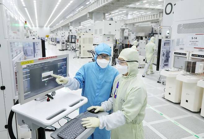 주성엔지니어링 황철주 회장(왼쪽)이 용인 R&D센터에서 직원과 대화하고 있다. 주성엔지니어링 제공