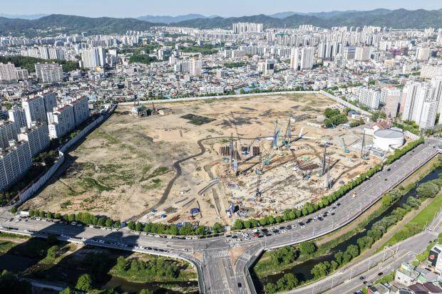광주시 북구 임동 29만6340㎡ 옛 전방·일신방직 부지 중앙에서 더현대 광주 공사가 한창인 가운데 오른쪽 원형 모델하우스 뒷편으로 4328세대 ‘올 뉴 챔피언스시티’ 예정 부지가 펼쳐져 있다 <광주일보 자료사진>