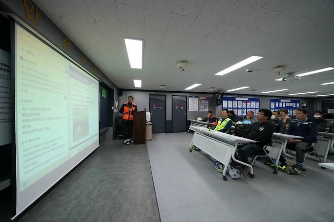 롯데건설 안전관리자가 한 아파트 공사 현장에서 ‘AI 근로자 다국어 번역 모델’을 활용해 외국인 근로자들을 대상으로 안전교육을 진행하고 있다./롯데건설 제공.