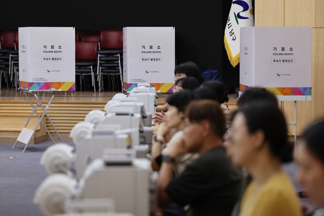 6·3 지방선거 사전투표를 하루 앞둔 28일 울산시 남구청 대강당에 마련된 사전투표소에 투표사무원들이 모의 투표를 하며 장비를 점검하고 있다. 연합뉴스