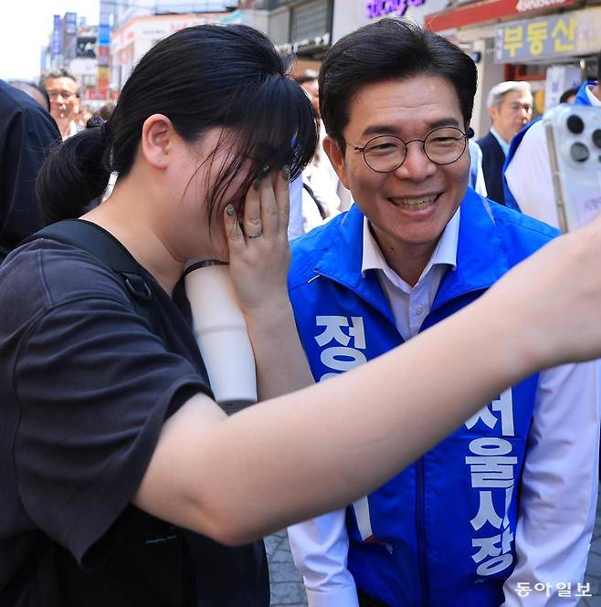 6·3 지방선거 사전투표가 시작된 29일 서울시장 선거에 나선 더불어민주당 정원오, 국민의힘 오세훈 후보는 나란히 대학가를 찾아 청년층 표심 잡기에 나섰다. 정 후보가 성북구 성신여대 유세 도중 한 시민과 셀카를 찍고 있다. 장승윤 기자 tomato99@donga.com