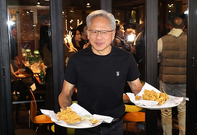 젠슨 황 엔비디아 최고경영자가 지난해 12월 30일 서울 삼성동 한 치킨집에서 진행된 이재용 삼성전자 회장, 정의선 현대차그룹 회장과 치맥 회동 중 시민에게 치킨과 감자튀김을 나눠주고 있다. 연합뉴스