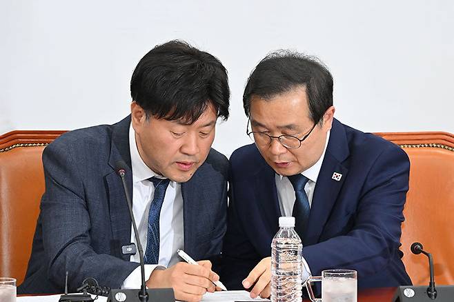 더불어민주당 김용 전 민주연구원 부위원장(왼쪽)과 이건태 의원이 4월 13일 국회에서 열린 ‘대장동 사건과 정치검찰 조작기소 의혹에 대한 기자간담회’에 참석해 대화하고 있다. 동아DB