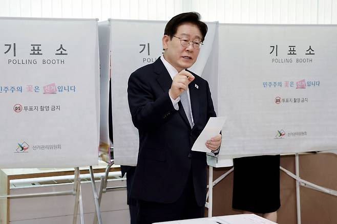 이재명 대통령이 사전투표 첫날 서울 종로구 삼청동 주민센터에서 사전 투표 중 기표 도장 관련 문의를 하고 있다. 연합뉴스.