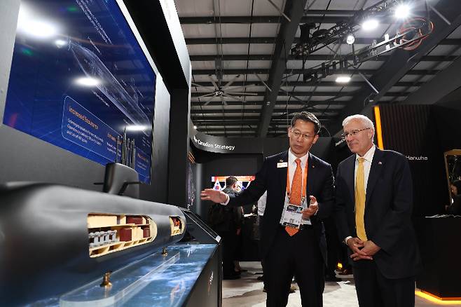 캐나다 오타와에서 열린 'CANSEC 2026' 전시회 내 한화오션 부스에서, 한화오션 특수선해외사업단장 정승균 부사장(왼쪽)이 빅터 피델리 온타리오주 경제개발부 장관에게 최신예 잠수함인 KSS-III 모델을 소개하며 그 우수성을 설명하고 있다. 한화오션 제공