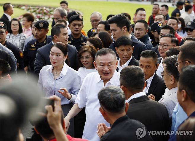 탁신 전 태국 총리, 수감 8개월 만에 가석방 지난달 11일(현지시간) 탁신 친나왓 전 태국 총리(가운데)가 가석방돼 방콕 교도소에서 나와 자기 딸인 패통탄 친나왓 전 총리(왼쪽)와 함께 자신의 지지자들에게 인사하고 있다.
