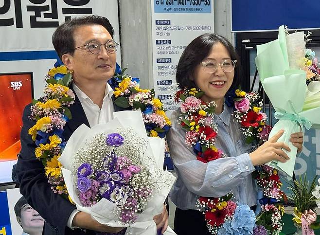 더불어민주당 김의겸(왼쪽) 후보가 3일 전북 군산·김제·부안갑 국회의원 재선거에서 당선이 확실시되자 꽃목걸이를 걸고 부인과 함께 기뻐하고 있다. 연합뉴스