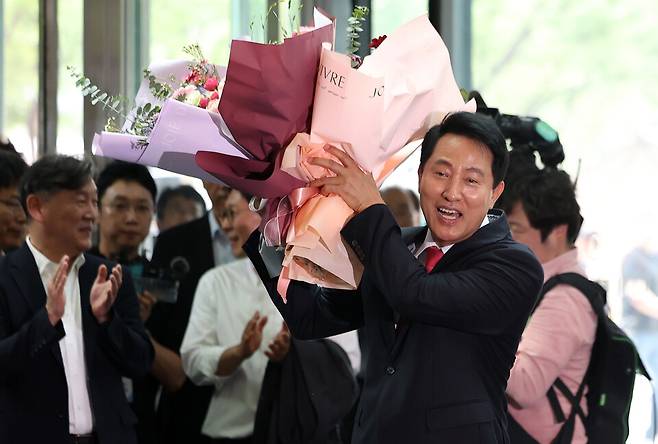 오세훈 서울시장이 4일 서울시청으로 들어서며 직원들에게 받은 꽃다발을 들고 있다. ⓒ 연합뉴스