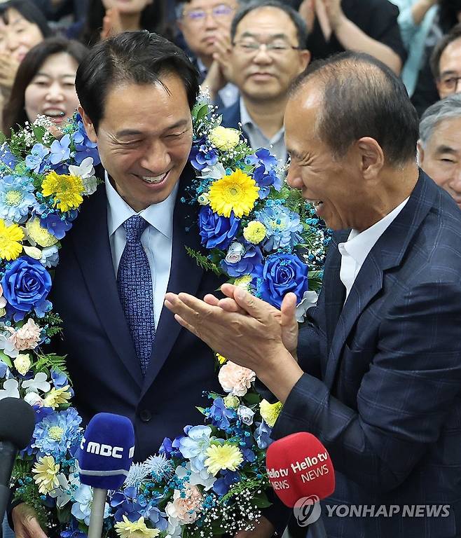 최문순 전 지사 축하 받는 우상호 강원도지사 후보 (춘천=연합뉴스) 양지웅 기자 = 더불어민주당 우상호 강원특별자치도지사 후보가 4일 춘천시 더불어민주당 강원도당에서 당선이 확실시된 뒤 최문순 전 지사로부터 축하받고 있다. 2026.6.4 yangdoo@yna.co.kr