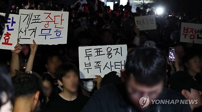 '부정선거' 외치는 시민들 (서울=연합뉴스) 김인철 기자 = 4일 제9회 전국동시지방선거 및 국회의원 재·보궐선거 투표용지 부족으로 투표 시간이 오후 10시까지 연장됐던 서울 송파구 잠실7동 제2투표소 앞에서 '부정선거' 등 손팻말을 든 시민들이 구호를 외치고 있다. 2026.6.4 yatoya@yna.co.kr