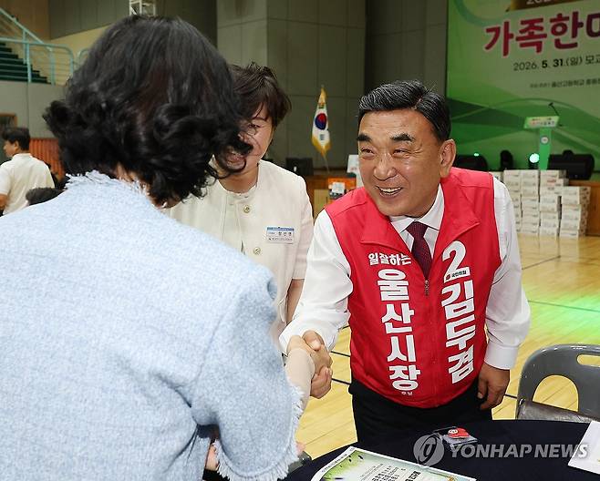 시민과 인사하는 김두겸 후보 (울산=연합뉴스) 김용태 기자 = 국민의힘 김두겸 울산시장 후보가 지난달 31일 울산 중구 울산고등학교에서 열린 총동창회 행사에 참석해 시민과 인사하고 있다. 2026.5.31 yongtae@yna.co.kr