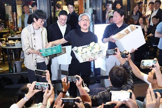 젠슨 황 엔비디아 최고경영자(CEO)가 5일 서울 마포구 홍대 인근 삼겹살 음식점 '형님 저요'에서 최태원 SK그룹 회장, 구광모 LG그룹 회장, 이해진 네이버 의장과 '삼소(삼겹살·소주) 회동’을 하며 각종 간식을 시민들에게 나눠주고 있다. 연합뉴스.