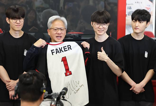 젠슨 황 엔비디아 최고경영자(CEO)가 5일 서울 마포구 ‘T1 베이스 캠프’를 방문해 ‘페이커‘ 이상혁을 비롯한 e스포츠 구단 T1의 리그 오브 레전드(LoL) 선수단에게 선물 받은 ‘페이커’ 사인 유니폼을 들어보이고 있다. /장경식 기자