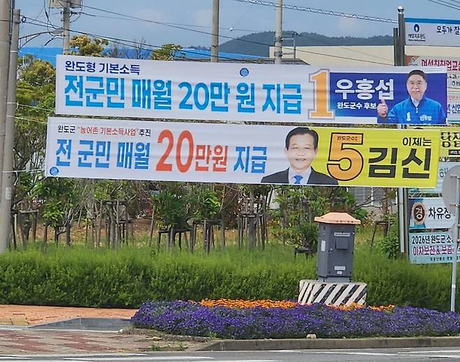 지난 5월 25일 오후, 완도군 읍내 가로변에 완도군수 선거에 출마한 민주당 우홍섭, 무소속 김신 후보의 농어촌기본소득 지급 공약을 담은 현수막이 걸려 있다. ⓒ시사저널 정성환