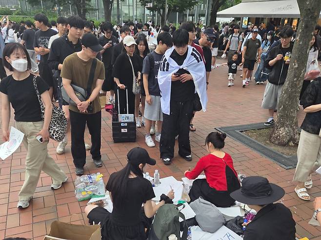 6일 오후 서울 송파구 올림픽공원역 앞에서 20·30 청년들이 태극기를 그리거나 '재선거'라는 문구를 적은 종이를 집회 참여자들에게 나눠주고 있다./독자 제공