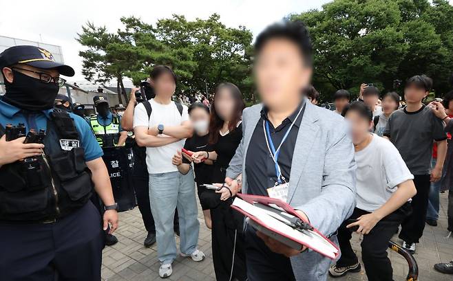 '투표지 부족 사태'를 규탄하며 재선거를 요구하는 '잠실 개표소 봉쇄 시위'가 계속되는 가운데 지난 5일 개표소인 서울 송파구 올림픽공원 핸드볼경기장에서 한 선거 관계자가 밖으로 나가려다 시위대에 가로막혀 건물 내부로 다시 들어오고 있다. 연합뉴스