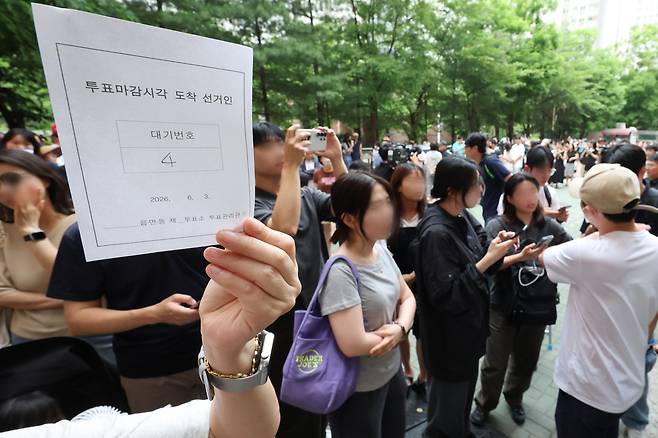 6·3 지방선거 본투표일인 3일 서울 송파구 잠실2동6투표소에서 투표용지 부족으로 유권자들이 대기하는 등 혼란이 빚어지고 있다. 한 시민이 투표 마감시간 이후 순서대로 투표가 가능하도록 정한 대기표를 받아 보여주고 있다. 연합뉴스