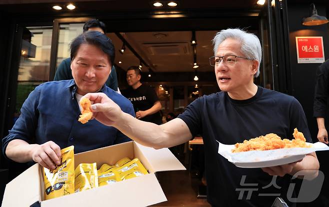 젠슨 황 엔비디아 최고경영자(CEO)와 최태원 SK그룹 회장이 7일 오후 서울 강남구 깐부치킨 삼성점에서 '치맥 회동' 중 시민 및 취재진에게 치킨을 나눠주고 있다. 2026.6.7 ⓒ 뉴스1 이호윤 기자