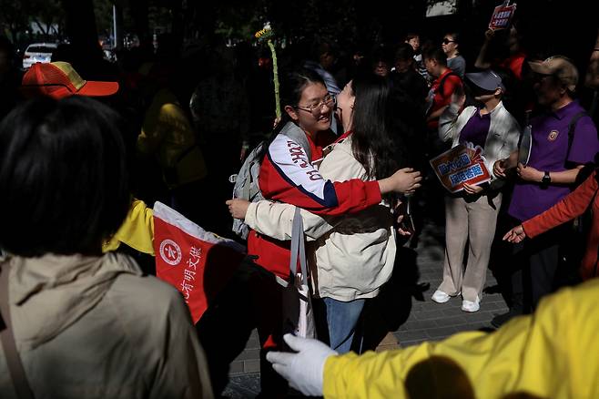 중국 베이징의 한 고교 교사가 7일 오전(현지시간) 중국의 대학 입학시험인 ‘가오카오’에 응시하는 학생이 시험장에 들어서기 전 응원해주고 있다. 로이터연합뉴스