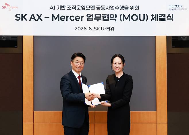 김완종 SK AX 사장(왼쪽)과 장지원 머서 코리아 공동대표가 경기도 성남시 SK AX 본사에서 'AI+휴먼 조직운영 모델 개발 및 에이전틱 AI 플랫폼 구축 공동 사업 수행 협약(MOU)'을 체결한 후 기념사진을 찍고 있다./SK AX