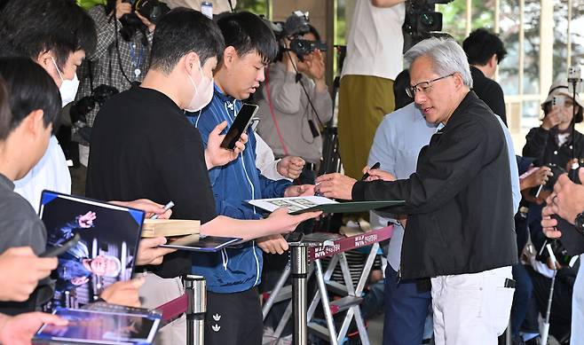 젠슨 황 엔비디아 최고경영자(CEO)가 9일 오전 서울 강서구 김포비즈니스항공센터에서 출국 전 팬들에게 사인을 하고 있다. 임세준 기자