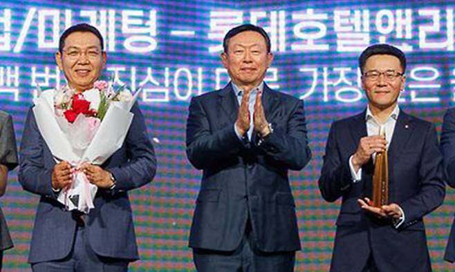 8일 롯데어워즈 대상을 시상한 신동빈 롯데 회장(가운데)과 대상을 받은 롯데호텔앤리조트의 정호석 대표(왼쪽). 롯데지주 제공