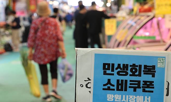 지난해 정부의 민생회복 소비쿠폰 지급으로 쿠폰 사용처였던 소상공인·자영업자의 매출이 추가로 약 2조8000억원 늘어난 것으로 추산됐다. 2025년 8월 26일 서울 마포구 망원시장 매장에 소비쿠폰 안내문이 붙어 있는 모습. 연합뉴스