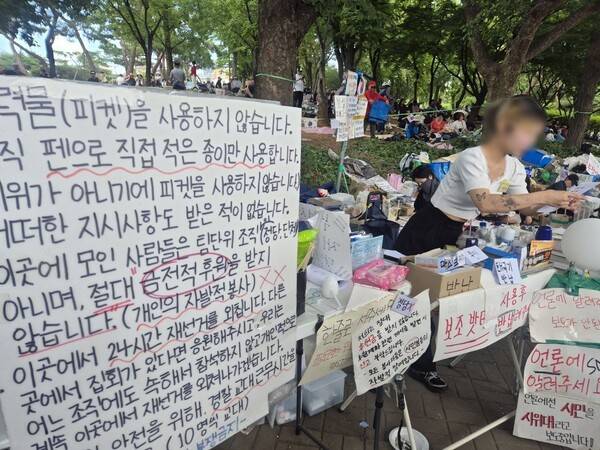 ▲지난 8일 서울 송파구 잠실 개표소로 쓰인 서울 올림픽공원 핸드볼경기장 앞 봉쇄 시위 현장 입구에 “출력물을 사용하지 않는다”는 장문의 육필 대자보가 걸려 있다. 기계로 출력한 피켓은 시위가 조직됐다는 의미라는 뜻에서다. “언론이 시민을 시위대라 보도 중이다” “시민들의 자발적 참여이다” 등 피켓도 눈에 띈다. 사진=김예리 기자