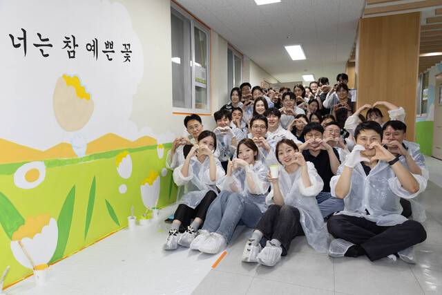 HMM 임직원들이 서울 은평구 아동복지시설에서 진행된 ‘아동복지시설 벽화 그리기 봉사활동’에 참여한 후 기념촬영을 하고 있다. HMM 제공