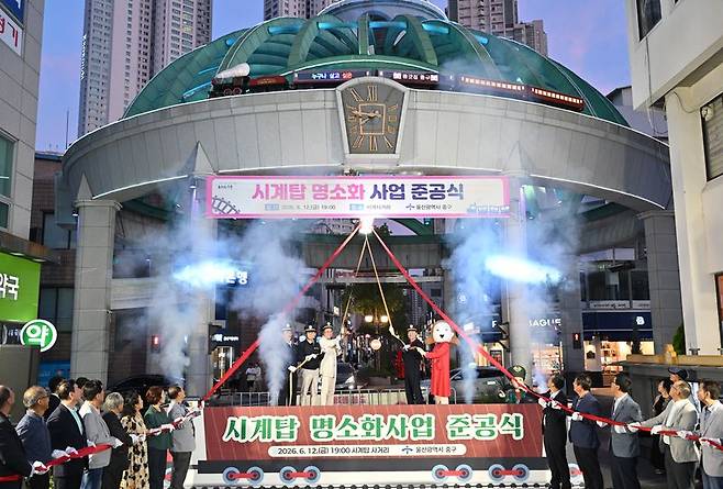 울산 시계탑 명소화 사업 준공식이 12일 성남동 시계탑 사거리 일원에서 김영길 중구청장과 시·구의원, 지역 주민 등이 참석한 가운데 열렸다. 현수막 위에 새로 제작된 모형 기차가 보인다. 울산 중구 제공