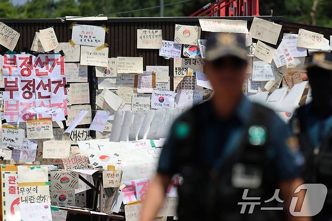 제9회 전국동시지방선거 투표용지 부족 사태를 규탄하는 개표소 봉쇄 시위가 11일째 이어진 15일 서울 송파구 올림픽공원 핸드볼경기장 티켓 부스 앞에서 경찰이 순찰을 돌고 있다. 2026.6.15 ⓒ 뉴스1 오대일 기자