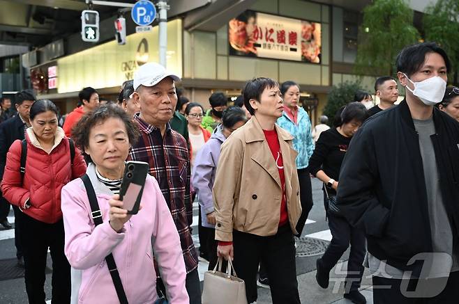 일본 도쿄 긴자의 쇼핑가에서 17일(현지시간) 중국인 관광객이 도로를 건너고 있다. 2025.11.17 ⓒ AFP=뉴스1