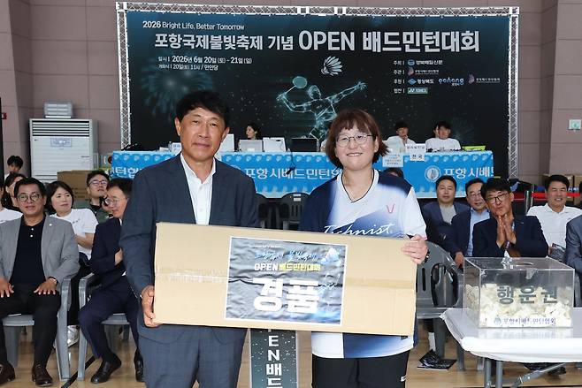 구미배드민턴협회 소속 한정희 씨(53)가 최윤채 경북매일신문 사장에게 행운권 경품인 다이슨 청소기를 전달받고 있다. /이용선기자 photokid@kbmaeil.com