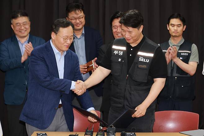 5월 20일 경기 수원시 장안구 경기고용노동청에서 임금협상 합의안에 서명한 후 여명구(앞줄 왼쪽) 삼성전자 반도체(DS) 부문 피플팀장과 최승호(오른쪽) 삼성그룹 초기업노동조합 삼성전자지부 위원장이 악수하고 있다. 공동취재사진