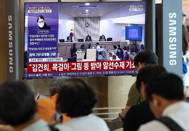 고가 귀금속과 함께 인사·이권 청탁을 받은 이른바 '매관매직' 혐의로 기소된 김건희 여사의 1심 선고가 열린 26일 서울역에서 시민들이 관련 방송을 지켜보고 있다. 연합뉴스