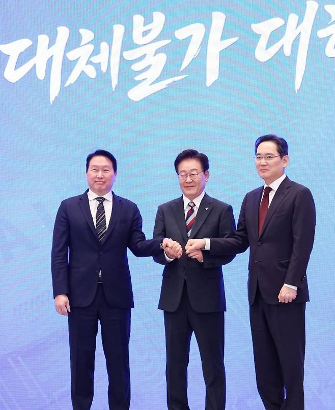 이재명 대통령과 이재용 삼성전자 회장, 최태원 SK그룹 회장이 29일 청와대에서 열린 3대 메가프로젝트 국민보고회에서 기업 투자 발표 후 손을 잡고 있다. 연합뉴스.