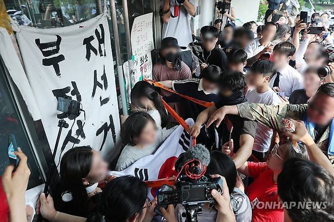 경기장 진입 막으려 문 꼭 쥔 시민 (서울=연합뉴스) 서대연 기자 = 6·3지방선거 투표용지 부족 사태로 촉발된 잠실 개표소 봉쇄 시위가 12일째 이어진 16일 서울 송파구 올림픽공원 핸드볼경기장 개표소 앞에서 시민들이 국민의힘과 대한체육회 관계자들의 진입을 봉쇄하기 위해 문을 잡고 있다. 2026.6.16 dwise@yna.co.kr
