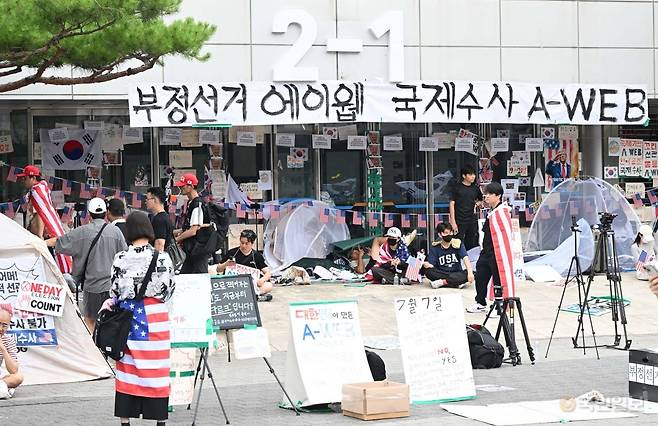국회 6·3 지방선거 투표용지 부족 사태 국정조사특별위원회가 현장 조사를 실시한 2일 서울 송파구 올림픽공원 핸드볼경기장 개표소 앞에서 시위대가 출입구를 막고 있다. 권현구 기자