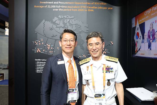'CANSEC 2026' 전시회 내 한화오션 부스를 찾은 김경률 해군참모총장(오른쪽)이 한화오션 특수선해외사업단장 정승균 부사장(왼쪽)과 기념촬영을 하고 있다. 한화오션 제공