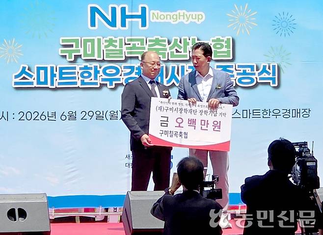 장영익 경북 구미칠곡축산농협 조합장(왼쪽)이 6월29일 준공식에서 김장호 구미시장에게 축산인재 육성을 위한 장학금 500만원을 전달하고 있다.