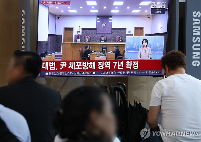 윤석열 전 대통령의 고위공직자범죄수사처(공수처) 체포방해 등 혐의 사건 상고심 선고기일인 9일 서울역에서 시민들이 관련 방송을 지켜보고 있다. 연합뉴스