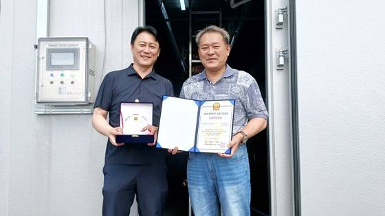 한국스마트팜의 이윤식 대표(사진 오른쪽)와 백동민 본부장이 '기술혁신대상'을 비대면 수상하고 기념사진을 촬영 중이다/사진제공=한국스마트팜