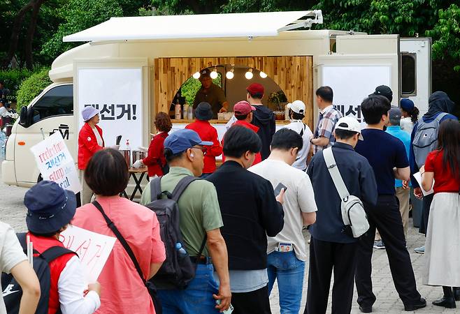 지난달 7일 서울 송파구 올림픽공원 핸드볼경기장에 마련된 커피차 앞에서 시민들이 커피를 받기 위해 줄을 서고 있다.