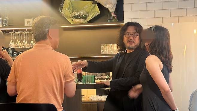 방송인 김어준(58)씨가 지난달 30일(현지 시각) 프랑스 파리의 한식당 ‘방드르디 구르망(Vendredi Gourmand·금요 미식회)’ 개업식에서 손님들과 대화하고 있다. /원선우 특파원
